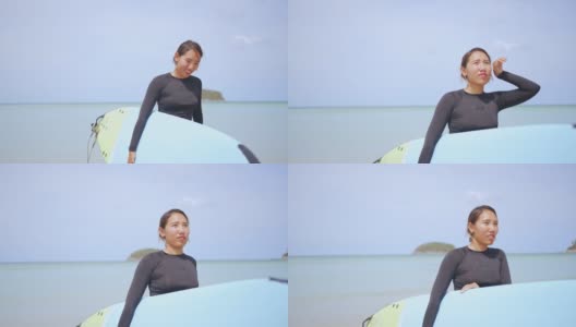 亚洲女人在莽撞的警卫手持冲浪板在海滩上行走高清在线视频素材下载