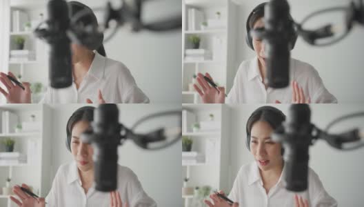 年轻的亚洲妇女在她的笔记本电脑从家庭工作室录制播客。高清在线视频素材下载