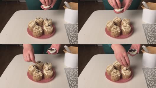 一位女士用奶油和饼干屑做海绵蛋糕。用奶油和巧克力末装饰。总体规划。高清在线视频素材下载