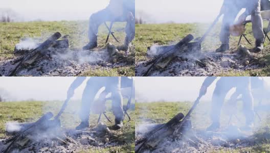 男纠正篝火中的煤高清在线视频素材下载