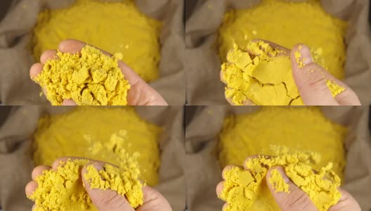 俯视图:人的手拿着一把姜黄粉放在一个囊上，然后把它扔出去-慢镜头高清在线视频素材下载