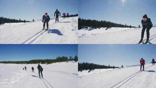 一组四名成年人的慢动作拍摄，因为他们在一个阳光明媚的冬天，在科罗拉多滑雪在一条线下山高清在线视频素材下载