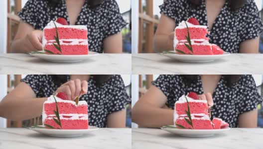 女人在咖啡馆吃草莓蛋糕的特写。高清在线视频素材下载