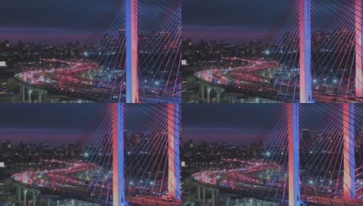 夜深时分，科修斯科大桥上的车流不断变换着颜色，背景是曼哈顿和布鲁克林的远处景色。航拍视频与平移摄像机运动。高清在线视频素材下载