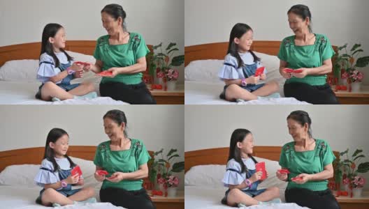 亚洲孙女春节期间在卧室里接受奶奶给的红包高清在线视频素材下载