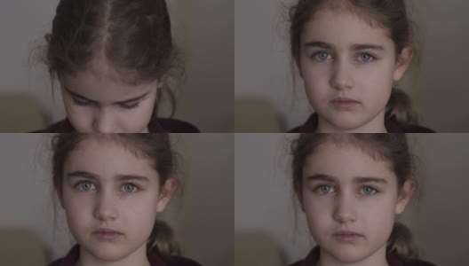 悲伤的小女孩看着相机。好奇的孩子在室内近距离看相机。沮丧的脸，严肃的眼睛，沉思的孩子。严重的学生在学校有问题高清在线视频素材下载