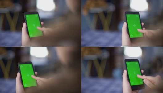 一名女性使用绿色屏幕的智能手机高清在线视频素材下载