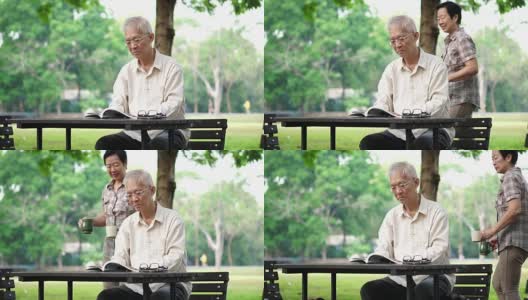 亚洲老年夫妇在美丽的公园早上喝咖啡高清在线视频素材下载