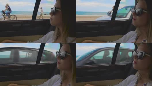 成功的女人坐在汽车后座沿着海滨度假城市高清在线视频素材下载