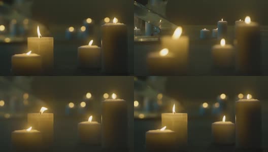 地板上有很多燃烧的蜡烛。蜡烛在黑暗中燃烧，玻璃烛台，黄色火焰的蜡烛，蜡烛站在地板上。高清在线视频素材下载