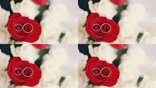 结婚戒指戴在玫瑰花束上。新婚夫妇的珠宝。婚礼配件高清在线视频素材下载
