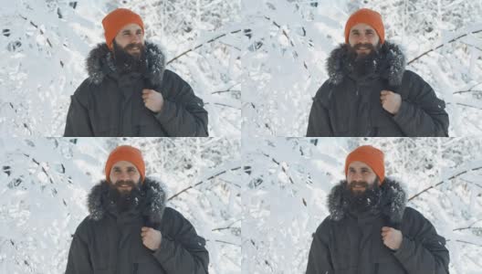 一名男子在一个冬日下雪天的户外对着镜头微笑和挥手高清在线视频素材下载