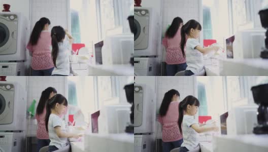 小女孩在厨房里帮妈妈干活高清在线视频素材下载