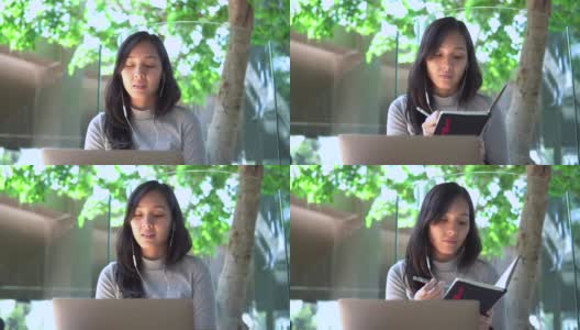 年轻的亚洲女性自由职业者使用她的笔记本电脑和工作在咖啡店高清在线视频素材下载