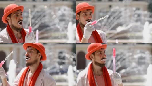 哑剧演员在街上的喷泉边吹肥皂泡。小丑在城市里表演素描。高清在线视频素材下载