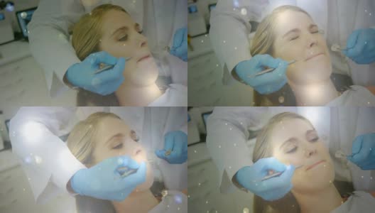 牙科医生治疗女性病人时，有发光的光点在移动高清在线视频素材下载