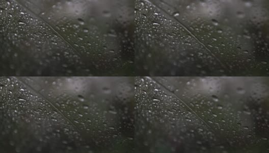 雨雪中的水滴顺着玻璃流下。下雨时汽车的挡风玻璃由内而外。高清在线视频素材下载