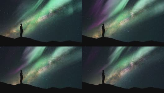 这个人站在星空下，拿着北极光。时间流逝高清在线视频素材下载