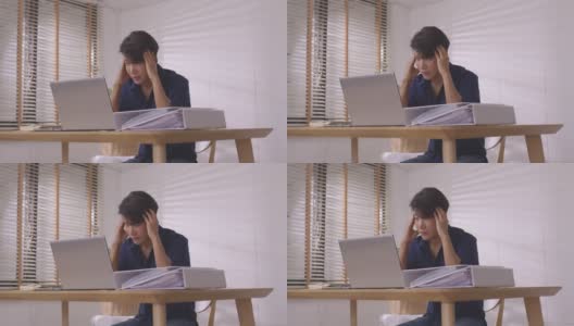 一名亚洲商人在家用笔记本电脑在线工作，感到头痛和疲劳。高清在线视频素材下载