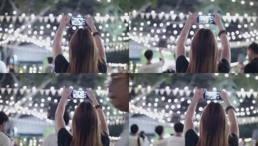 女人用智能手机在晚上的婚礼上拍照高清在线视频素材下载