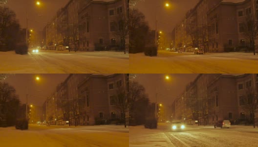 汽车行驶在白雪覆盖的街道上，中欧，夜晚高清在线视频素材下载