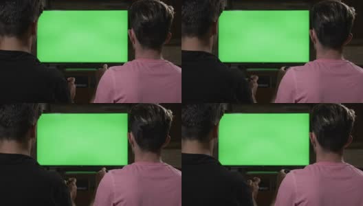 几个令人不寒而栗的家伙在沙发上用彩色键绿色电视屏幕上的手柄玩视频游戏高清在线视频素材下载