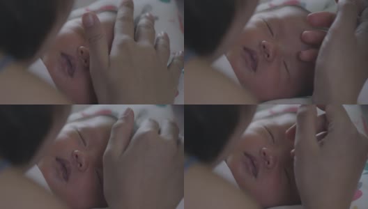 靠近可爱的亚洲新生女婴正在睡觉和母亲触摸她的脸与温柔和爱。幸福的家庭的概念。高清在线视频素材下载