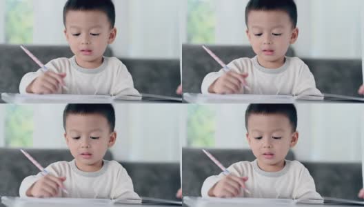 亚洲男孩做家庭作业，教育-孩子在餐桌上学习，家庭学校。高清在线视频素材下载