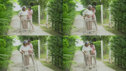 亚洲的高级马瑟与沃克和成年的女儿在花园里散步。老妇残疾人步行和照顾年轻妇女帮助后院公园户外。保健家庭生活方式高清在线视频素材下载