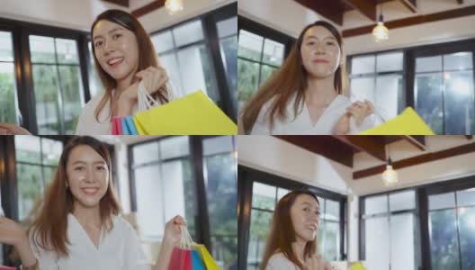 快乐的亚洲女人感觉悠闲地拿着购物袋，在客厅里跳来跳去高清在线视频素材下载