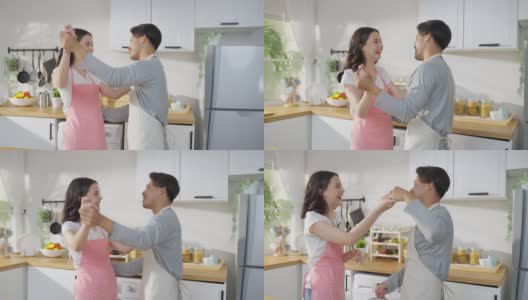亚洲迷人的情侣们在家里的厨房里一起跳舞。美丽浪漫的新婚男女系上围裙，感觉幸福，在家里享受活动关系，听音乐。高清在线视频素材下载