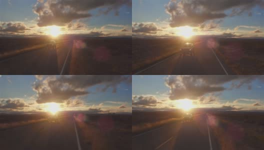 图片:金色的夕阳下，一辆黑色SUV行驶在空旷的乡村道路上高清在线视频素材下载