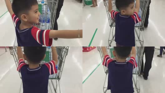 Lฺฺฺ小男孩用父母推手推车购物高清在线视频素材下载