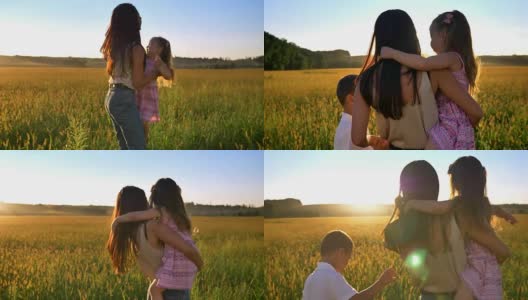 母亲抱起女儿的剪影，带着孩子在夏天的田野里散步，家庭观念高清在线视频素材下载