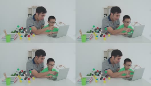 亚洲男孩学生与父亲视频会议电子学习与教师电脑学习在家里的科学教学。在家教育和远程学习，在线，教育和互联网。高清在线视频素材下载
