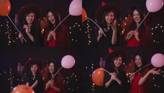 万圣节前夕穿着女巫服装并拿着气球的亚洲妇女。高清在线视频素材下载