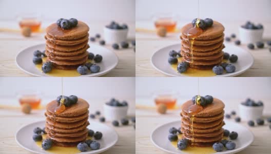 巧克力煎饼，蓝莓和蜂蜜放在盘子里高清在线视频素材下载