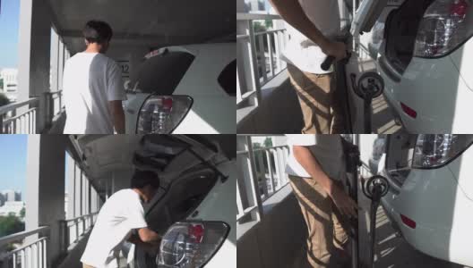 一名男子在汽车后备箱里搬运电动滑板车。侧视图高清在线视频素材下载