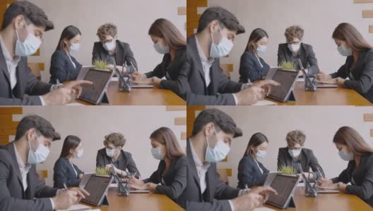 多民族商务人士戴着防护口罩，在办公室开会高清在线视频素材下载