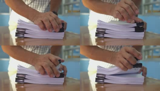 商人的手在办公室桌子上翻找文件一叠叠的文件来寻找报告文件，一叠叠的文件和桌子上的夹子。高清在线视频素材下载