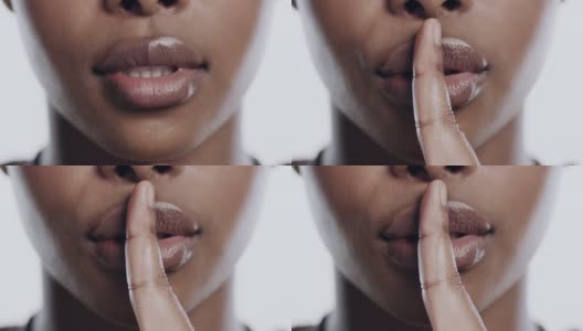 4k视频记录了一个陌生女人独自站在演播室里把手指放在嘴唇上高清在线视频素材下载