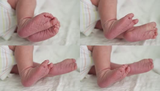 可爱的小婴儿光脚和脚趾头的第一天的生活在白色的背景。靠近小腿干燥的婴儿皮肤婴儿甜蜜地睡在柔软舒适的床上。童年,孕妇的概念高清在线视频素材下载