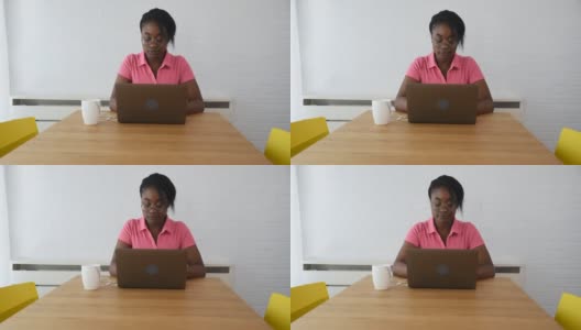 年轻的非洲黑人女商人，自由职业者，网络开发人员，在她的笔记本电脑上工作，从家里在新项目上使用她的知识，为问题解决公司雇用她高清在线视频素材下载