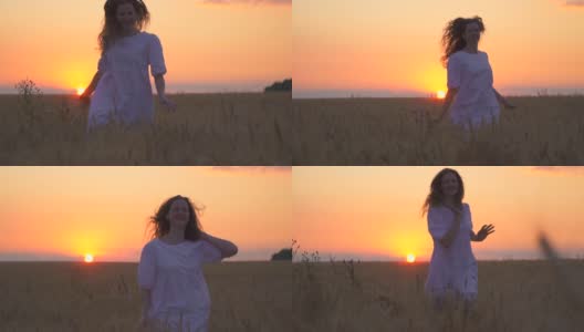 一个漂亮的白人女人在战场上奔跑。这个女孩在尽情地跳舞。大自然母亲。享受日落。地平线上的太阳是金色的。高清在线视频素材下载