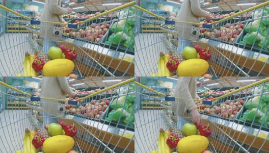 推着手推车在超市买新鲜蔬菜和水果的妇女高清在线视频素材下载