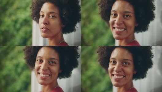 一个快乐的年轻拉丁人的近距离肖像与棕色的眼睛，非洲式的头发和鼻子穿孔为相机摆姿势。美丽多样的多民族黑人西班牙裔女性微笑在绿色的自然背景。高清在线视频素材下载