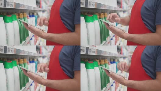 在超市的货架上，售货员用数码平板电脑高清在线视频素材下载