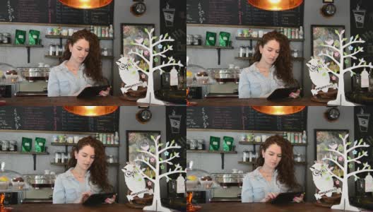 年轻女咖啡师在用平板电脑高清在线视频素材下载