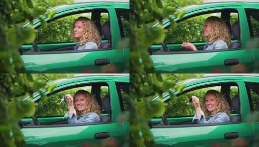坐在绿色车里的女人展示她的车钥匙高清在线视频素材下载