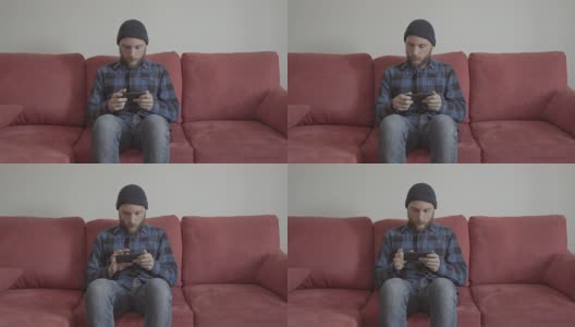 大胡子男人坐在家里的红色沙发上高清在线视频素材下载
